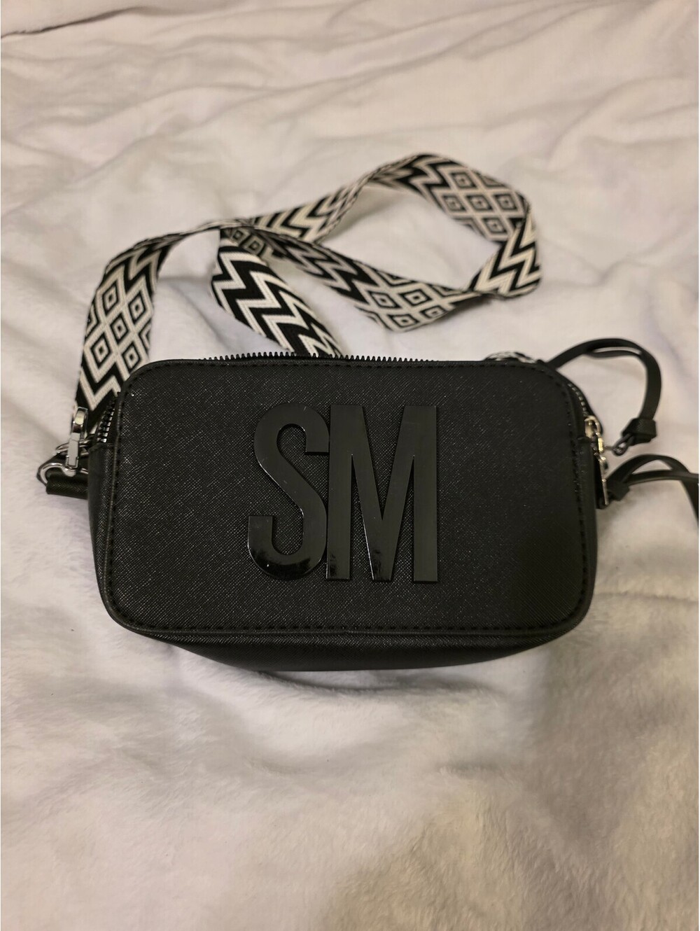 Black camera crossbody bag with patterned strap